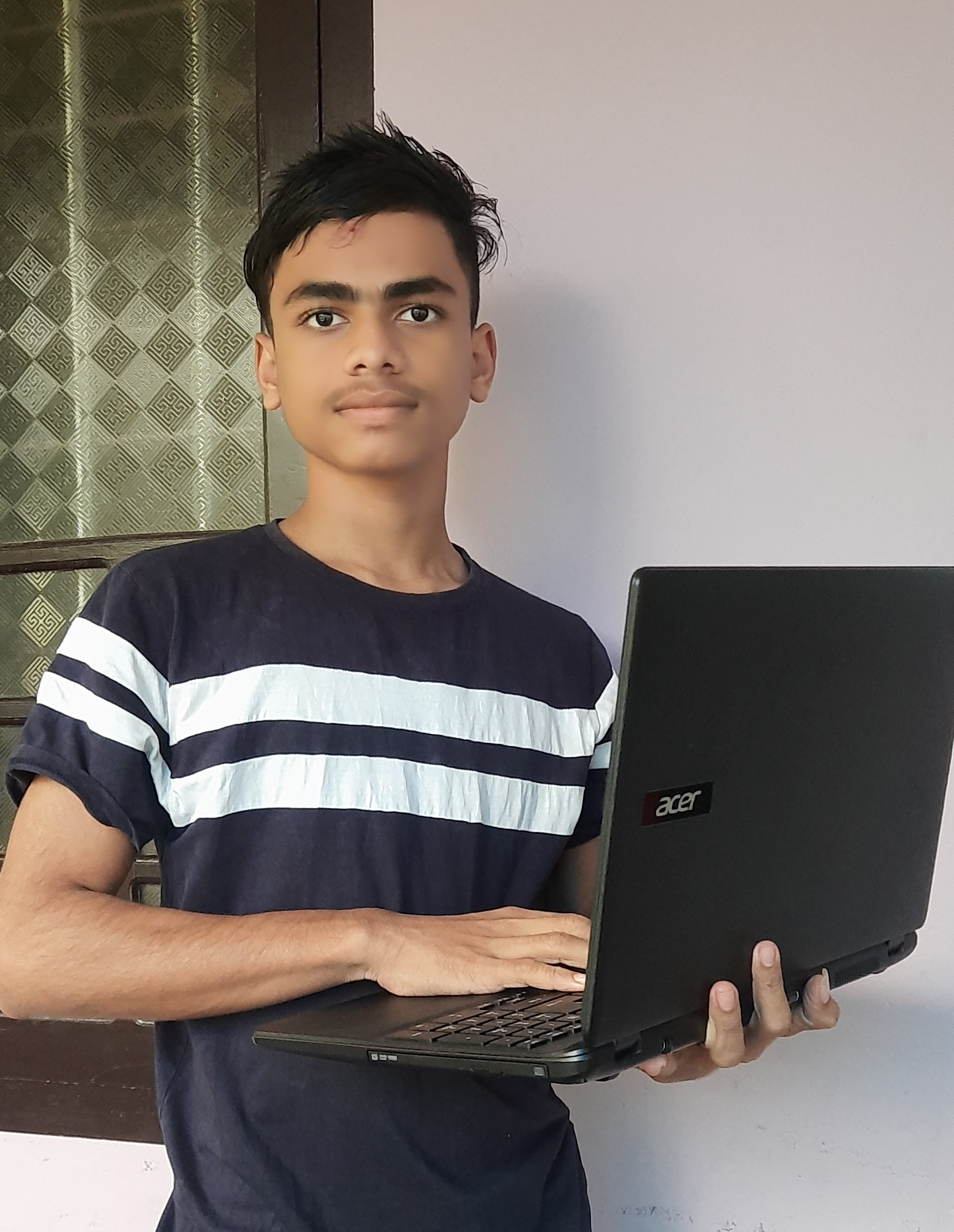 Sajad in 2022 holding his first laptop, a gift from a family member